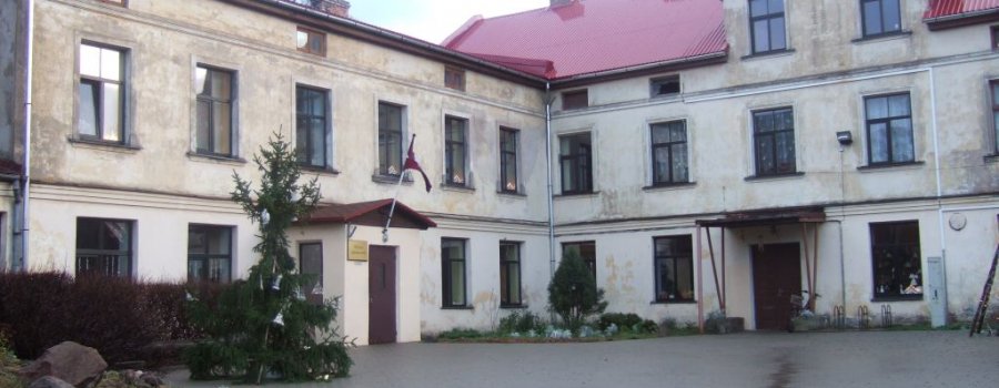 Tukuma mākslas skolas ēka ar sarkanu jumtu un daudziem logiem.